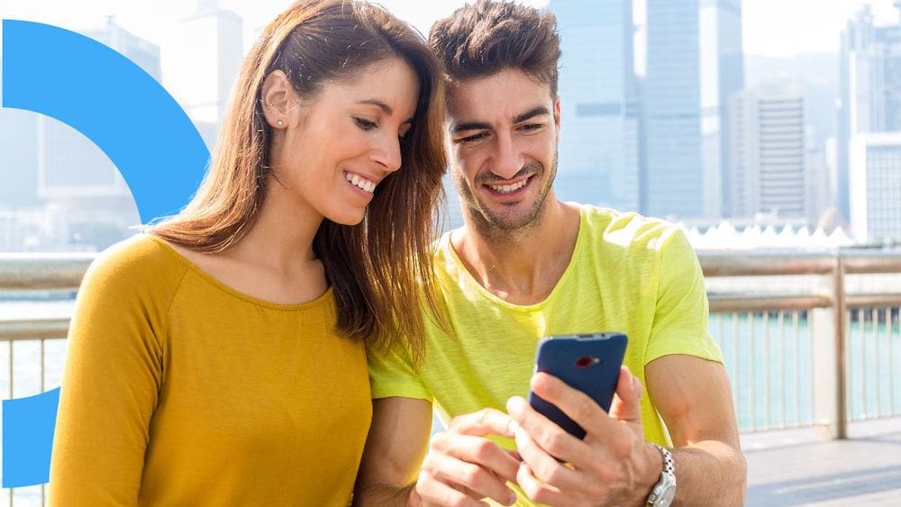 Couple on vacation using mobile loyalty apps on a smartphone