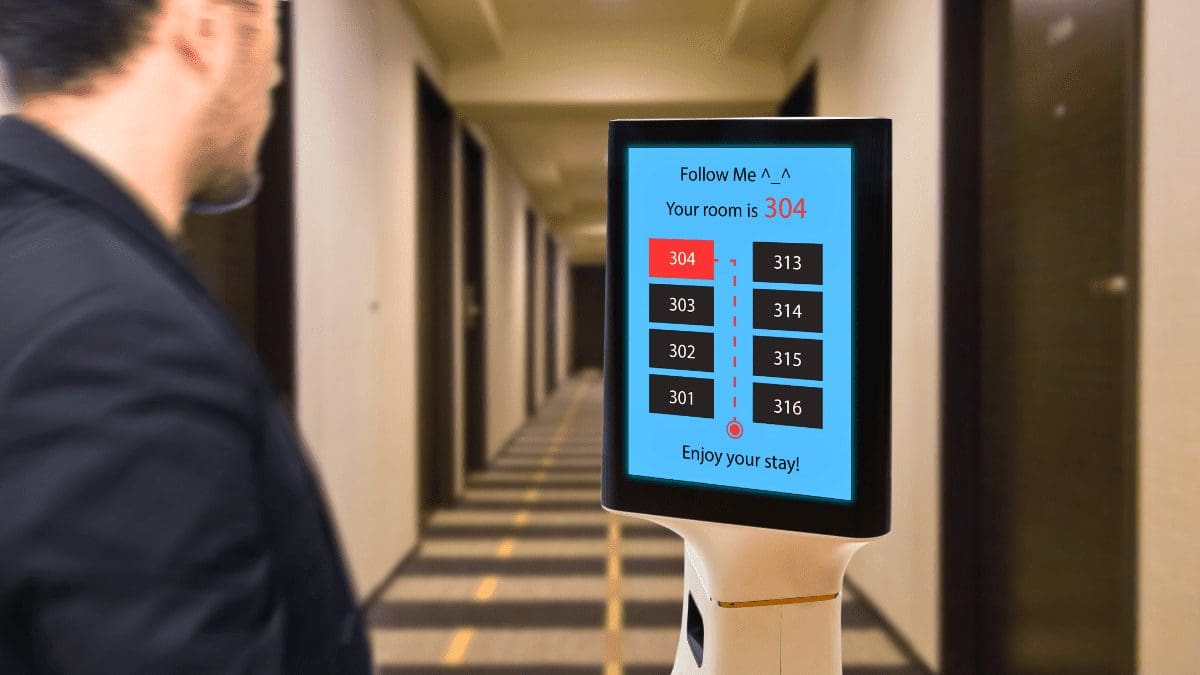AI-powered robot in a hotel showing a man to his room.