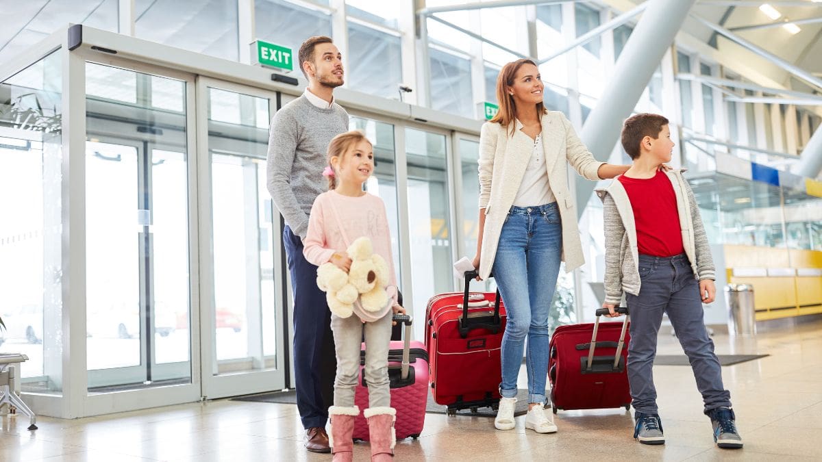 Family entering an airport for a vacation booked using a whitelabel cashback rewards program.