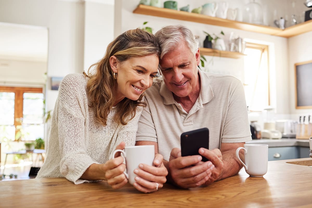 Senior couple on smartphone reading online loyalty program perks.