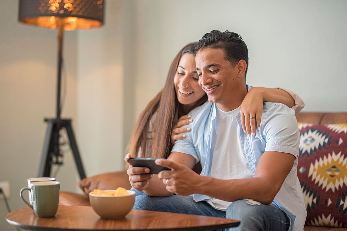 happy young couple using a smartphone to review rewards